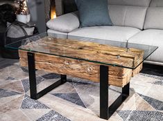 a wooden table with glass top sitting in front of a couch