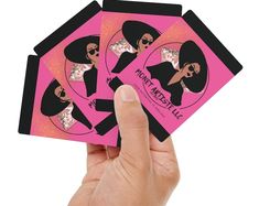 a hand holding up four pink cards with black women on them