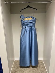 a blue dress hanging on a hanger in a closet