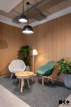 two chairs and a table in an office with wood paneling on the wall behind them