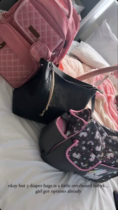 three purses are stacked on top of each other in the middle of a bed