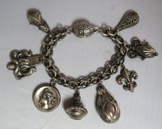 Here's a chunky 1950s charm bracelet in silver tone metal.  It features a wide chain and 8 large charms that are styled like vintage watch fobs.  Measures 7 long and is in good vintage condition with a magnetic clasp.   Please see the picture with a coin for size comparison, as items may appear larger than they actually are. This is necessary to provide accurate details. Thanks for looking. And thank you for shopping sustainably. Silver Vintage Bracelets With Vintage Charm, Vintage Collectible Charm Bracelet, Vintage Engraved Charm Bracelet, Antique Metal Charms For Collectors, Retro Silver Metal Charm Bracelet, Retro Silver Jewelry With Charms, Vintage Metal Jewelry With Dangling Charms, Antique Charm Bracelet With Vintage Charm, Silver Retro Charm Bracelet