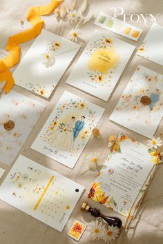 the wedding stationery is laid out on top of the table with yellow ribbons and flowers