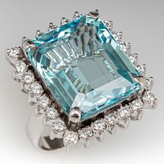 This marvelous ring is centered with one (1) emerald cut natural aquamarine set into a four-prong setting. The center stone is bordered with twenty-six (26), prong set, round brilliant cut diamonds. The ring measures 23.1mm at the top, rises 12.6mm above the finger, tapering to 3.4mm wide and 0.9mm thick at the base of the shank. This ring is currently a size 6.25. Aquamarine Cocktail Ring, Shape Fashion, Aquamarine Jewelry, Aquamarine Ring, Diamond Cocktail Rings, Aquamarine Rings, Natural Aquamarine, Blue Gemstones, Boutique Shop