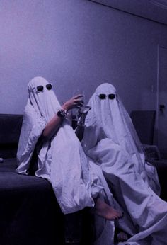 two people in white cloths sitting on a couch