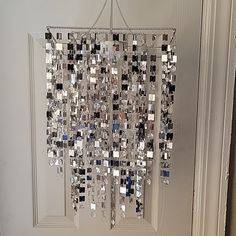 a white door with a chandelier hanging from it's side in front of the door