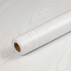 a roll of white paper sitting on top of a wooden floor