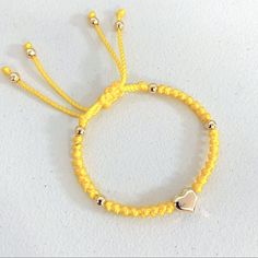 New. Stainless Steel Puffed Heart Ajustable Knotted Bracelet. Color Yellow. Handmade With 6mm Golden Stainless Steel Beads Enclosed With Knots On A Braided Cord Creating A Stylish Design. A Focal Stainless Steel Puffed Heart Is The Star Of This Bracelet. Adjustable With Macrame Sliding Closure. Wear It Alone Or Create Stacks Combinations With More Bracelets. Perfect Gift For Valentines Day, Mother’s Day, Christmas, Birthdays, Anniversaries Or Simply For Yourself. Gold Heart Friendship Bracelets With Sliding Knot, Adjustable Yellow Gold Heart Bead Bracelet, Adjustable Yellow Jewelry With Heart Beads, Adjustable Yellow Gold Heart Bracelet With Heart Beads, Yellow Beaded Bracelets With Heart Beads For Gifts, Adjustable Yellow Gold Bracelet With Heart Beads, Yellow Beaded Bracelets With Sliding Knot As Gift, Yellow Beaded Bracelets With Sliding Knot For Gifts, Yellow Beaded Bracelet With Sliding Knot As Gift