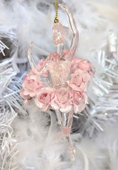 a glass ornament with pink flowers and a ballerina figure hanging from it