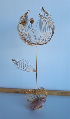 a metal wire sculpture with flowers in it