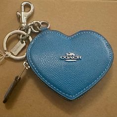 a blue heart shaped keychain sitting on top of a cardboard box