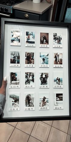 a person holding up a black and white framed photo with pictures on the inside of it