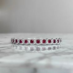 This elegant ruby and diamond bangle bracelet is crafted from 18K white gold and boasts 106 natural diamonds and 13 rubies of superior (G) color and (VS2) clarity for a total of 4.17CTW. Brilliantly cut and carefully prong set, this bracelet adds timeless sophistication to any ensemble. Red Diamond Bracelet Fine Jewelry, Red Diamond Bracelet In Fine Jewelry Style, Fine Jewelry Red Diamond Bracelet, Red Diamond Fine Jewelry Bracelet, Red Diamond Bracelets Fine Jewelry, Round Ruby Tennis Bracelet For Wedding, Red Diamond Tennis Bracelet For Weddings, Red Diamond Bracelet For Wedding, Red Diamond Bracelet With Gemstone