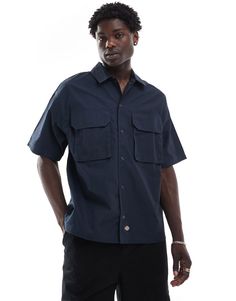 T-Shirt by Dickies No need to keep scrolling Spread collar Snap placket Chest pockets Regular fit Navy Button-up Shirt With Pockets, Cotton Shirt With Side Pockets And Short Sleeves, Cotton Short Sleeve Shirt With Side Pockets, Short Sleeve Camp Shirt With Pockets For Work, Short Sleeve Utility Shirt With Flap Pockets, Utility Shirt With Flap Pockets And Short Sleeves, Casual Navy Collared Short Sleeve Shirt, Casual Blue Tops With Flap Pockets, Short Sleeve Tops With Patch Pockets For Work