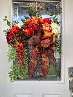 a basket filled with flowers sitting on top of a door