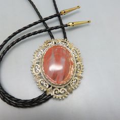 Handmade Big Oval Cherry Quartz Bolo Tie, Made in Montana by PandPF on Etsy Western Style Gold Lariat Jewelry, Vintage Engraved Lariat Jewelry, Adjustable Gold Concho Jewelry, Vintage Gold Lariat Bolo Tie, Gold Adjustable Cord Bolo Ties For Gift, Vintage Lariat Jewelry With Sliding Knot, Gold Lariat Bolo Tie With Adjustable Length, Vintage Jewelry With Adjustable Length For Formal Occasions, Adjustable Gold Bolo Tie As Gift