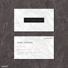 two white marble business cards with black text on the front and bottom, sitting on a dark background