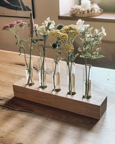 five vases with flowers in them sitting on a table