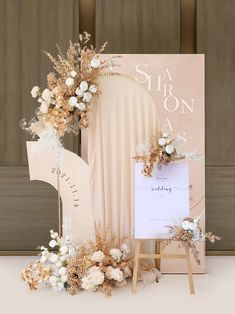 the wedding sign is surrounded by flowers and an easel with a card on it