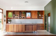 a kitchen with wooden cabinets and stainless steel sink in the center, along with hardwood flooring