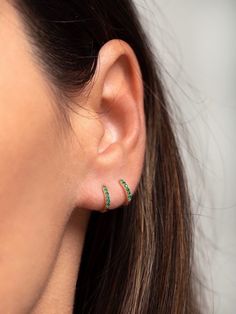 "An all-time bestseller with emerald green zirconia stones. Elegant and classic, these tiny huggie hoops prong-set with brilliant zirconia gemstones are a beautifully dainty addition to your everyday lineup. Subtle, versatile and perfect to mix and match with other earrings. ∙ Sold individually (1 hoop) or by pair (2 hoops). * D E T A I L S * ∙ Material: .925 Sterling Silver or 18K Gold Plated over .925 Sterling Silver ∙ Stone: Green Zirconia ∙ Dimensions: Hoop Diameter: 11mm // Width: 1.5mm ∙ H Cheap Green Hoop Earrings, Small Hoop Green Earrings For May Birthstone, Dainty May Birthstone Hoop Earrings, Green Huggie Earrings With Matching Set, Small Green Pierced Hoop Earrings, Green Small Hoop Huggie Earrings For May Birthstone, Dainty Green Huggie Hoop Earrings, Everyday Green Huggie Earrings, Hypoallergenic Round Hoop Earrings For May Birthstone