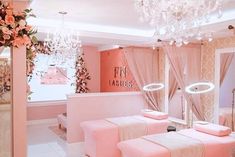 a pink room with chandeliers and flowers on the ceiling, two benches in front of a mirror