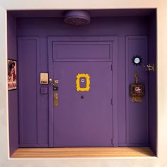 a purple door with yellow knobs on the front and side panels is in a white frame