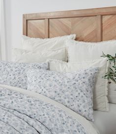 an unmade bed with blue and white flowers on it