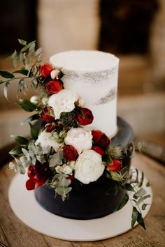 a wedding cake with red and white flowers on top