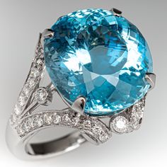 This spectacular ring is centered with an oval mixed cut aquamarine, weighing 13.75 carats, in a four-prong setting. The top of the ring is accented with fifty-two (52) bead set round brilliant cut diamonds and four (4) bezel set, round brilliant cut diamonds. The ring measures 19.5mm at the top, rises 11.9mm above the finger, tapering to 2.6mm wide and 1.4mm thick at the base of the shank. This ring is currently a size 6.75. Aquamarine Ring Vintage, Aquamarine Cocktail Ring, Large Stone, Gold Cocktail Ring, Gold Cocktail, Aquamarine Jewelry, Bead Set, Dress Rings, Pretty Rings