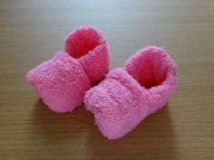 two pink slippers sitting on top of a wooden table