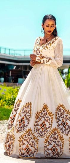 This gorgeous Habesha dress for a wedding is a breathtaking ensemble that showcases the beauty of Ethiopian traditions and celebrates the joyous union of two souls. Meticulously crafted with handwoven fabric, intricate embroidery, Menen fabric, and thread design, it exudes elegance and grace. The foundation of this dress lies in the handwoven fabric, a testament to the skill and artistry of Ethiopian weavers. Using traditional techniques, they intricately weave luxurious cotton or silk threads t