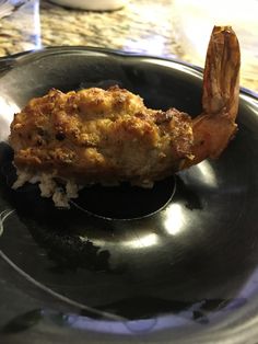 a black plate topped with food and a fork