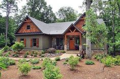 a house in the woods with lots of trees and shrubs around it, surrounded by greenery