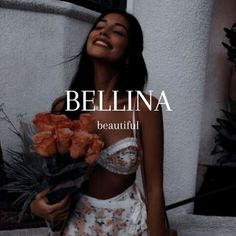 a woman holding flowers in her hand and smiling at the camera with text that reads, bellina beautiful