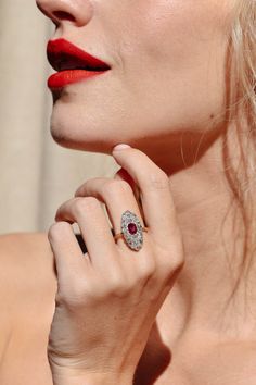 This antique Edwardian ruby and diamond ring circa 1915 combines the glow of a natural untreated Burmese ruby with the sparkle of old mine cut diamonds in one pleasing design. At the heart of this ring gleams a GIA certified cushion cut natural untreated Burmese ruby, approximately .56 carats in weight. This precious gemstone possesses a vivid red hue and remains untreated, allowing its natural beauty to shine through. The ruby is set amidst a navette shaped cluster of variously sized old mine c Navette Ring, Erstwhile Jewelry, Antique Cushion Cut, Antique Cushion, Burmese Ruby, Ruby And Diamond Ring, The Glow, Ruby Diamond, Engraved Items