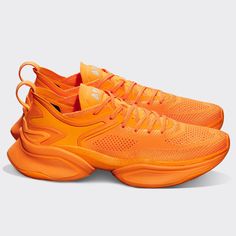 an orange pair of basketball shoes on a white background