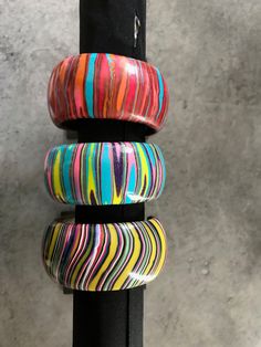 three bracelets are stacked on top of each other in front of a gray wall