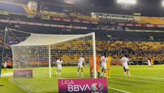 the soccer players are getting ready to kick the ball into the goalie's net