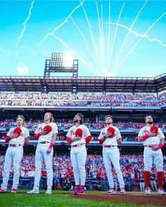 a group of baseball players standing on top of a field in front of a crowd