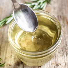 a spoon in a jar filled with olive oil