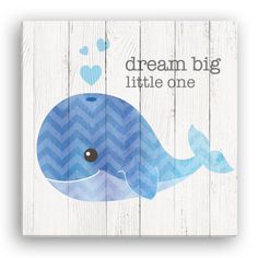 a blue whale with the words dream big little one on it's chest, against a white wooden background