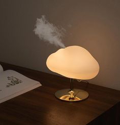 a lamp that is sitting on top of a table next to a book and some papers