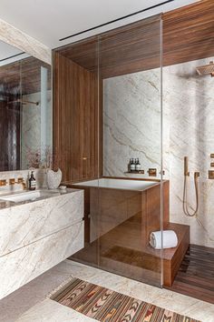 a bathroom with marble walls and flooring next to a walk - in shower stall