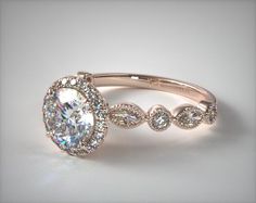 a white gold ring with an oval shaped diamond surrounded by smaller round diamonds