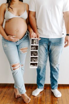 a pregnant woman standing next to a man holding an image of her baby bump in the belly