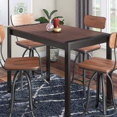 a dining room table and chairs with a rug on the floor