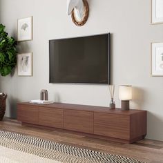 a flat screen tv mounted to the side of a wooden cabinet in a living room