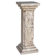 a white marble pedestal with an intricate design on the top and bottom, standing against a white background