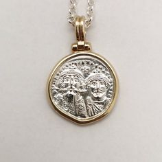 Byzantine-era coins were believed to be talismans against evil spirits, their mystical energy would give prosperity and luck to the one wearing them. It was a common practice to give such coins as gifts to newborns to protect them. This is a special statement piece, a hand-forged solid 14k yellow gold frame holds a solid sterling silver coin, exact copy of the ancient one, and hangs from a silver chain creates an ideal layering necklace. Elegant, classy, boho, classic and modern at the same time Antique Gold Sterling Silver Coin Necklace, Antique Sterling Silver Gold Coin Necklace, Hammered Coin Jewelry For Gift, Hammered Coin Jewelry Gift, Ceremonial Coin-shaped Engraved Jewelry, White Gold Coin Pendant Jewelry For Commemoration, Ceremonial Engraved Coin Jewelry, Ceremonial Engraved Coin-shaped Jewelry, Commemorative White Gold Coin Pendant Jewelry